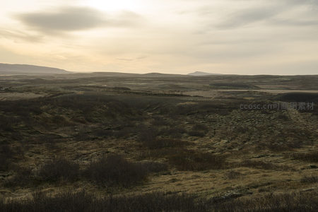 黄昏下的荒原地貌与远山剪影
