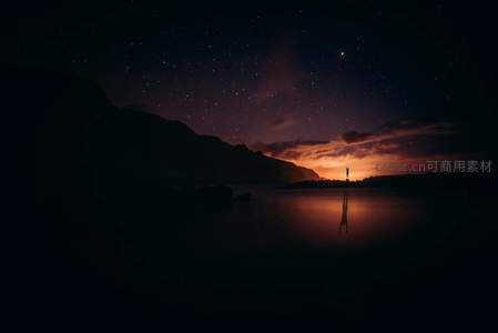 星空下的孤独剪影与湖面倒影