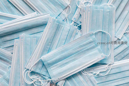 大量医用口罩堆叠，象征公共卫生防护需求