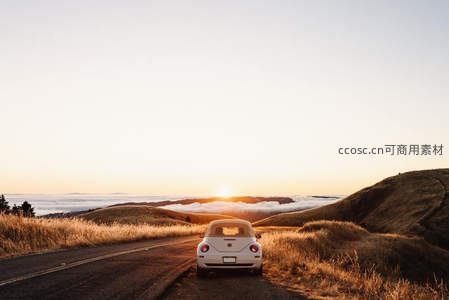 白色甲壳虫车停山路看云海日落
