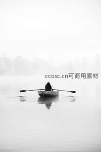 雾中孤舟一人划桨的宁静水墨画
