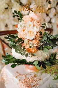 精致婚礼蛋糕，鲜花绿叶环绕，浪漫温馨