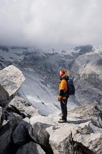 登山者立峰顶远眺冰川云海