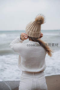 海边女子背影，毛线帽与海浪相映成趣