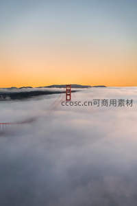 金门大桥塔尖穿云破雾，日出染霞