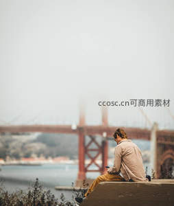 雾中静坐凝望金门大桥的人