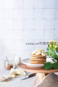 木架上的香蕉松饼堆叠，点缀绿叶与黄花