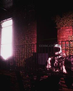 红光笼罩下宇航员蹲坐于铁栅栏后