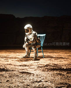 宇航员独坐蓝色椅子于荒漠，灯光聚焦显孤寂