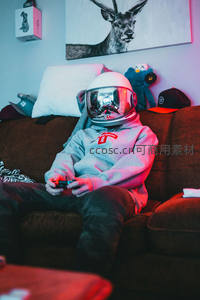 年轻人戴宇航头盔沙发打游戏炫彩灯光