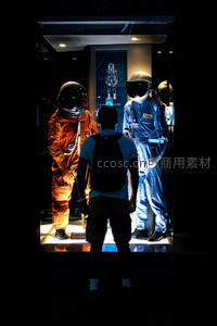 参观者凝视展柜中的宇航服