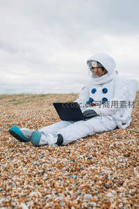 宇航员海滩使用笔记本电脑