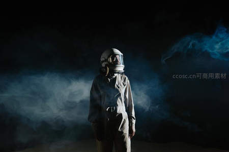宇航员在烟雾弥漫的黑暗中凝视前方