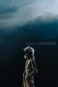 戴头盔的宇航员仰望烟雾弥漫的天空