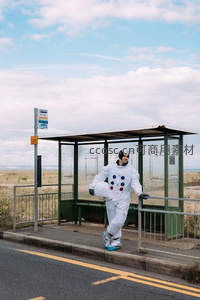 宇航员在路边公交站活泼跳跃显活力