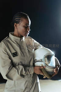 女宇航员轻抚头盔，神情沉静专注