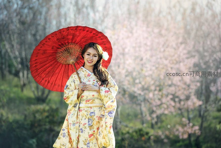 樱花树下和服少女持红伞微笑