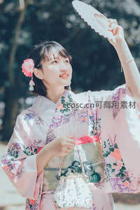 和服少女举扇迎光，花饰发间展笑颜