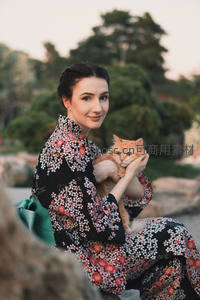 花园中女子怀抱橘猫笑靥如花