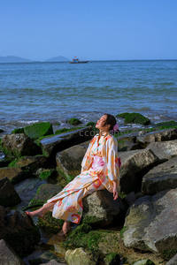海边礁石上的和服女子，享受阳光海风