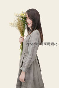 微笑女子手捧雏菊，温柔侧颜尽显春日气息