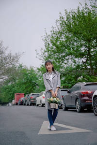 街头女子手捧鲜花漫步