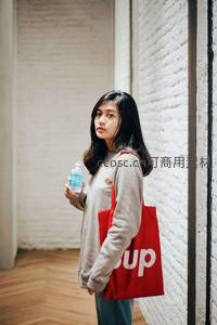 手提红色帆布包的简约文艺女孩