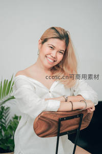 白衣女子微笑倚椅