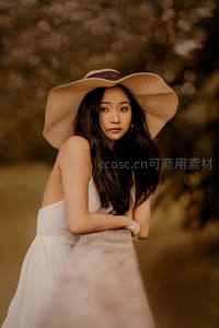 戴草帽女子倚栏凝望远方