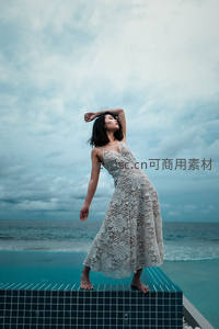 海边泳池边，白裙女子优雅伫立