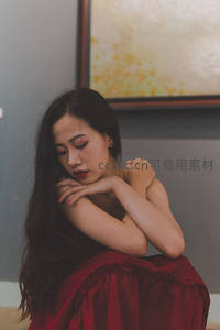 红裙女子沉思蜷坐角落