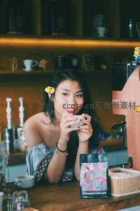 咖啡馆里微笑的女子手捧咖啡杯