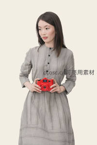 灰裙女子手持红色相机