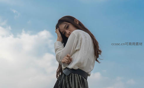 蓝天白云下少女沉思侧影