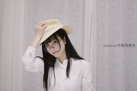戴帽眼镜女微笑调整帽檐