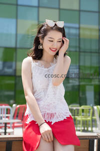 红裙白衫女子户外微笑倚坐