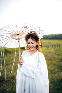 白衣古风女子持伞立于田野