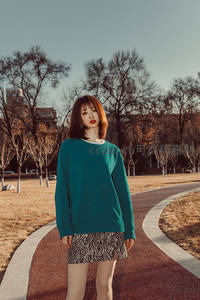 公园小径上红发女孩静谧伫立