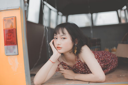 红裙少女倚货车尾厢托腮沉思