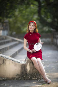 旗袍美人持扇倚坐石阶