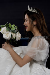 新娘侧颜微笑手捧白玫瑰花束