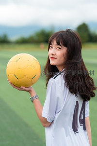 足球少女球场回眸手托黄球