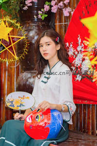 手持团扇与面具，红扇映衬古韵