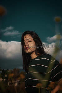 风中长发飘扬的少女仰望天空