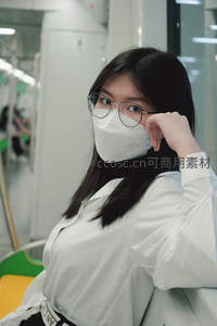 地铁车厢内戴口罩的年轻女子
