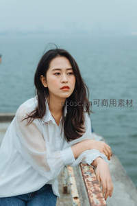 海边栏杆旁的沉思女子