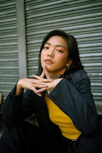 黑衣黄内搭女子优雅托腮