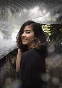 微笑女子在银色遮阳布下回眸