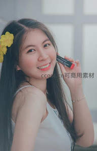 黄花点缀发间，手持口红展笑颜