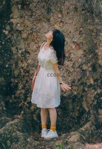 树影下的少女仰望天空，享受自然宁静